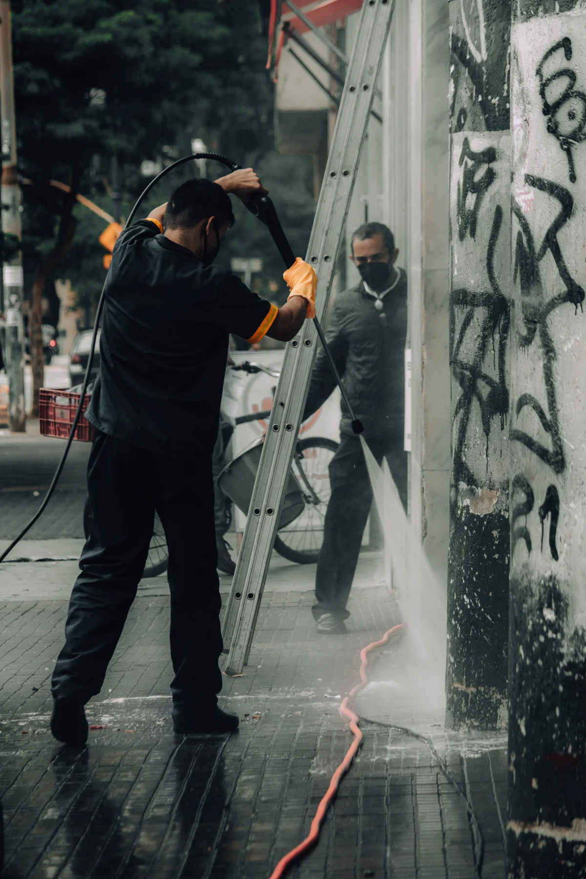 Graffitientfernung an einer Fassade mit Hochdruckreiniger – Stockfoto von Thom Gonzalez